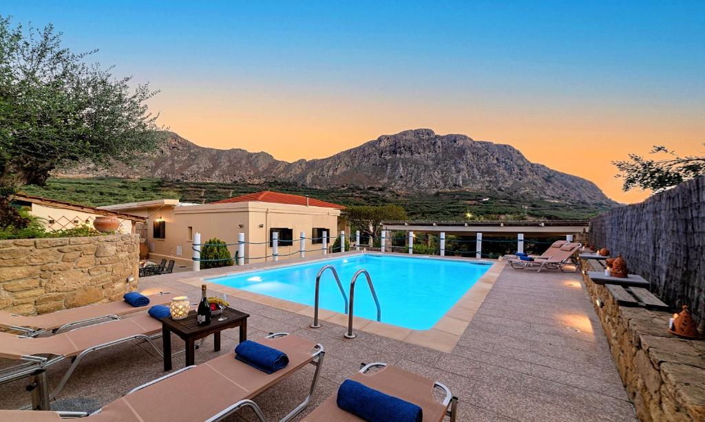 a villa with a swimming pool with mountains in the background at Cretan Kera Villa Heated Pool in Kerá