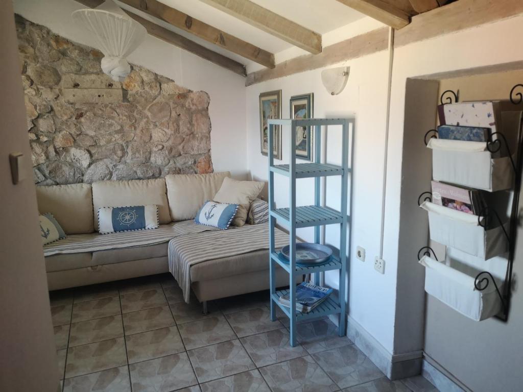 a living room with a couch and a stone wall at Charming dalmatian apartment with panoramic view in Tkon