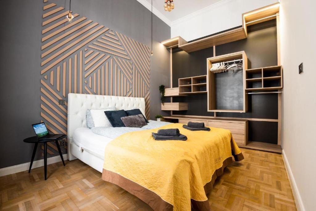 a bedroom with a bed with a yellow blanket on it at Deluxe Quentin Home next to the Fashion Street in Budapest