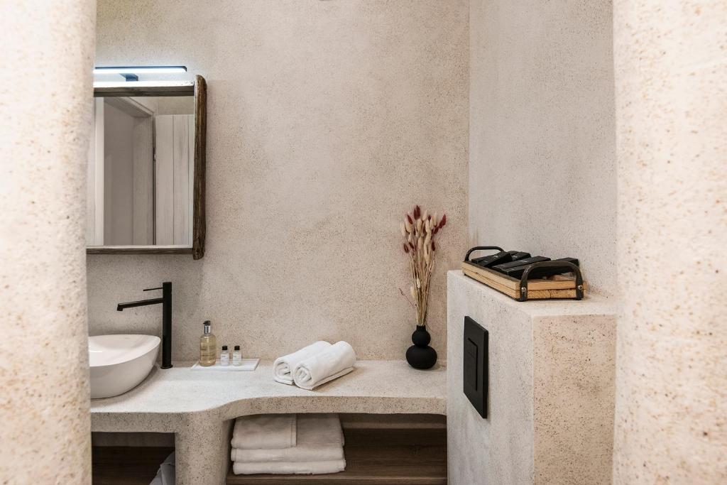 La salle de bains est pourvue d'un lavabo et d'un miroir. dans l'établissement Athena Luxury Studios, à Athènes