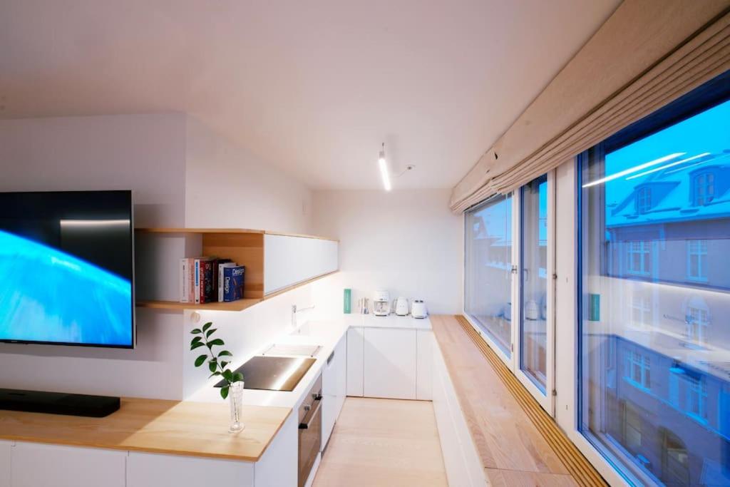 ヘルシンキにあるCentral Studio Nordic Styleの白いキャビネットと大きな窓付きのキッチン