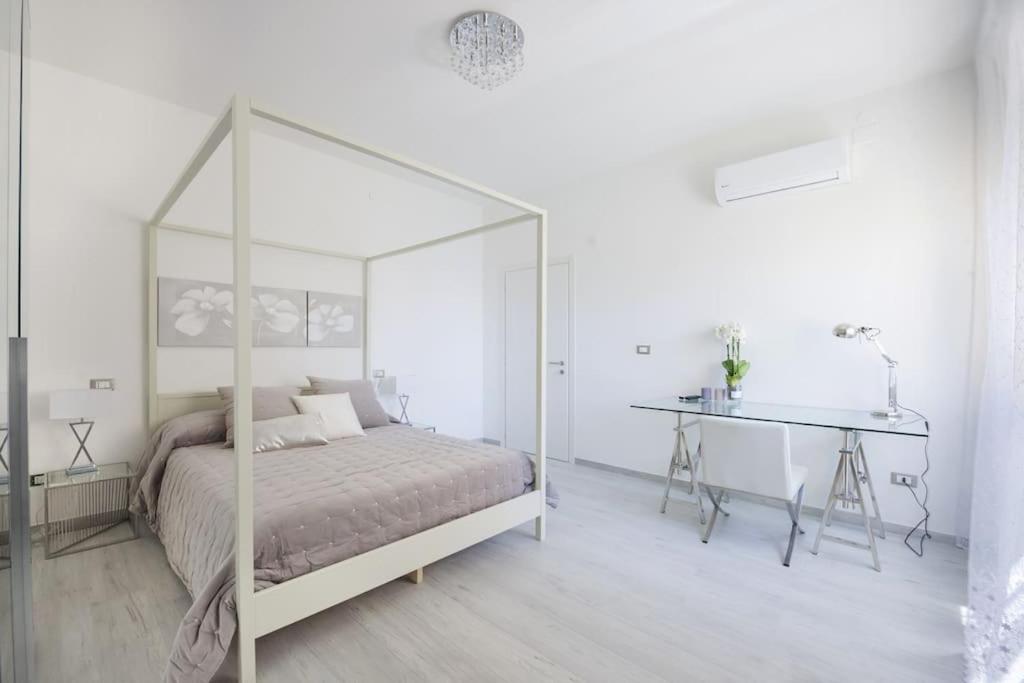 una camera bianca con letto a baldacchino e scrivania di La dolce vita - Pescara Centro a Pescara