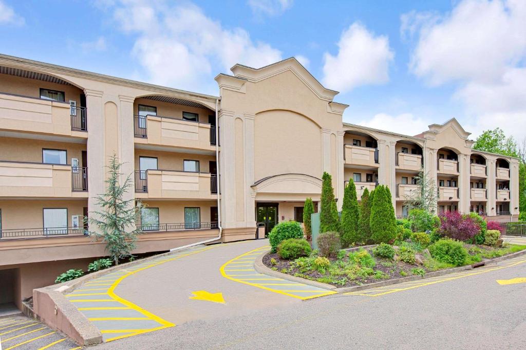 an apartment building with a road in front of it at Travelodge by Wyndham Parsippany in Parsippany
