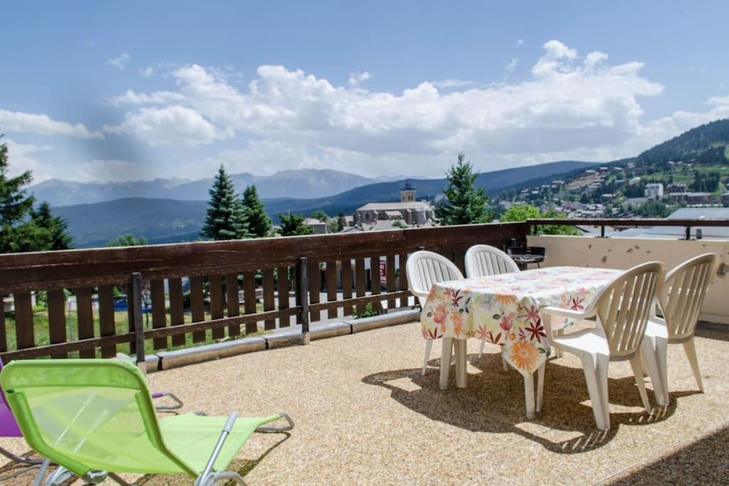 stół i krzesła na balkonie z widokiem w obiekcie T2 cabine avec terrasse plein sud 30m2 aux angles w mieście Les Angles