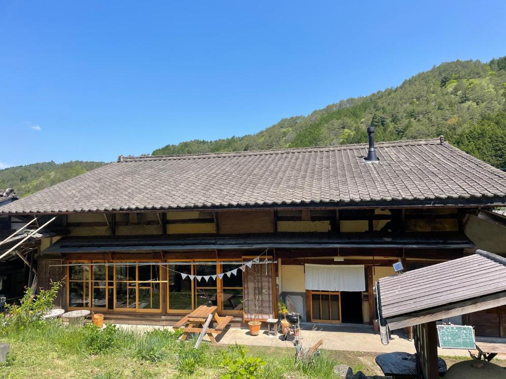 a large wooden house with a mountain in the background at Guesthouse Soranoie in Gero