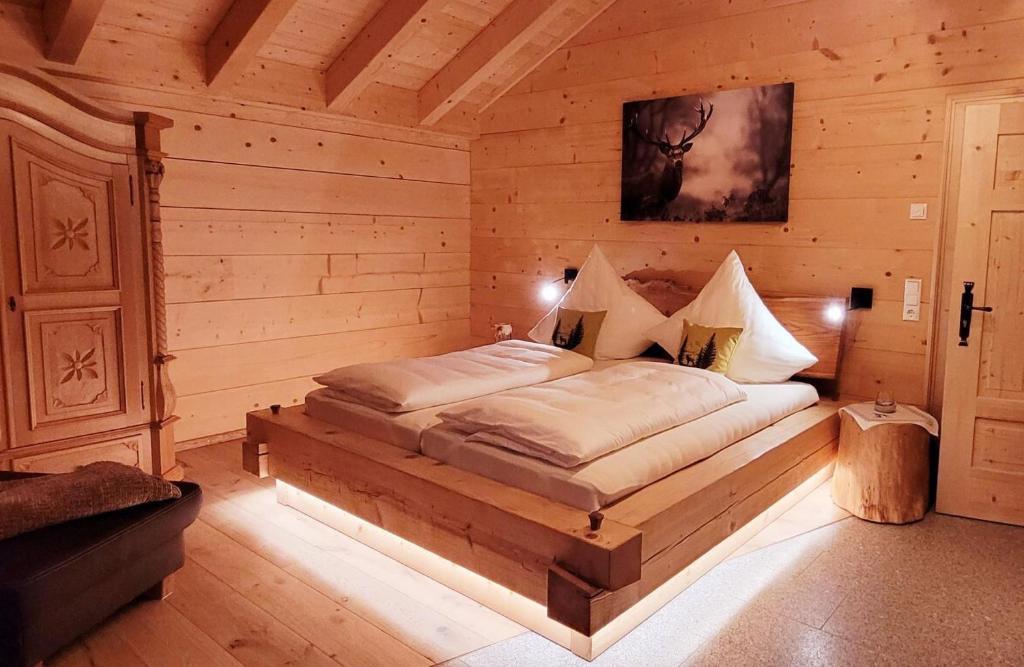 1 dormitorio con 1 cama en una habitación de madera en Chalet Bauer en Drachselsried
