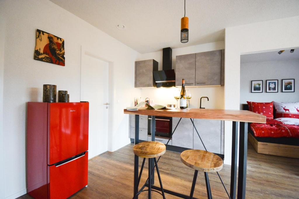 a kitchen with a red refrigerator and a counter with stools at BLACKFOXREST Ferienwohnung in Feldberg