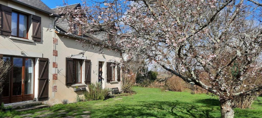 un árbol florido delante de una casa en La Villonnière, en Parnac