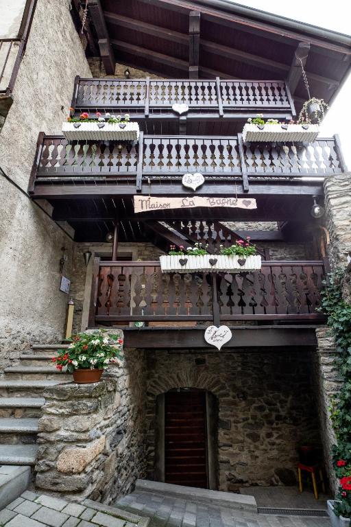 een stenen gebouw met trappen en balkons met planten bij Maison La Bagne in Aosta