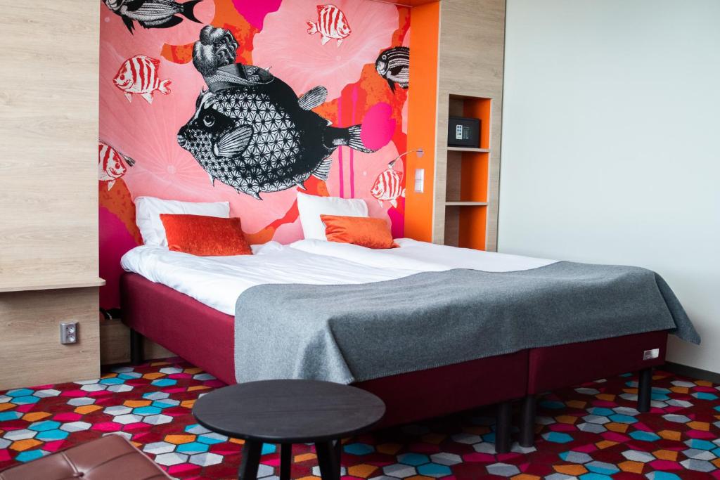 a bedroom with a bed with a colorful wall at Motel L Lund in Lund