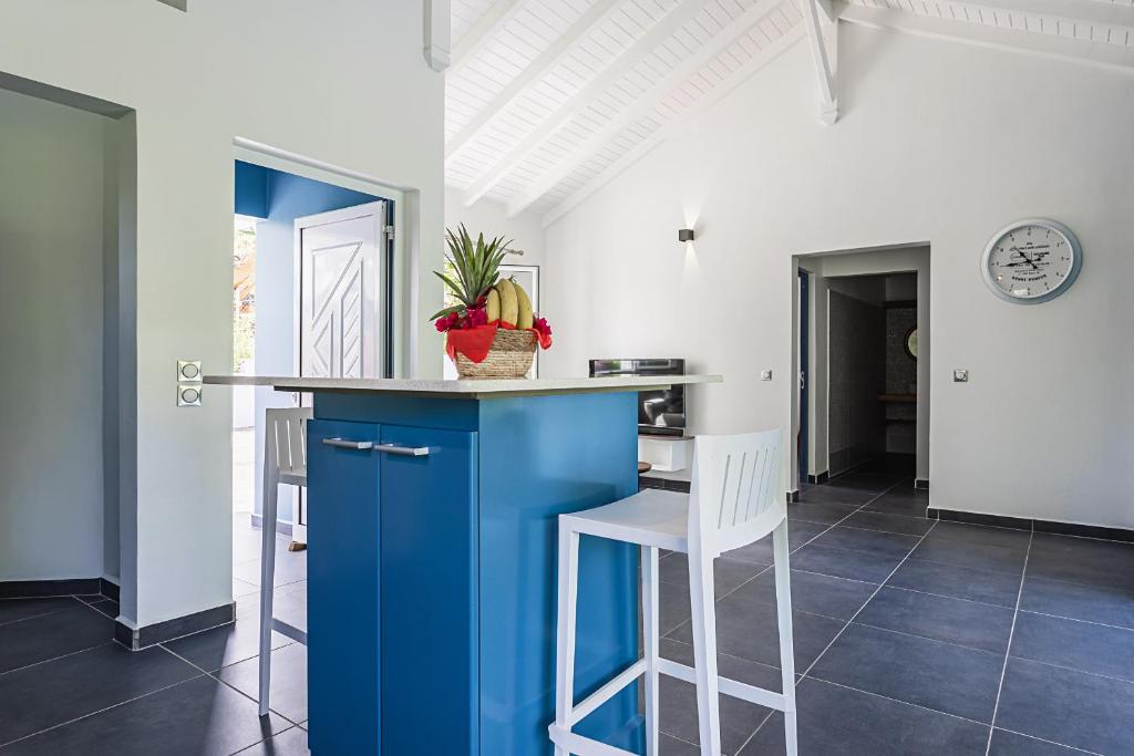 a kitchen with a blue island in a room at Villa Plumbago in Sainte-Anne