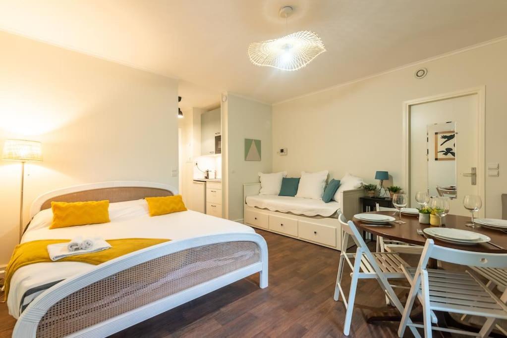 een slaapkamer met een bed, een tafel en een bank bij Appartement proche Champs Elysées in Parijs