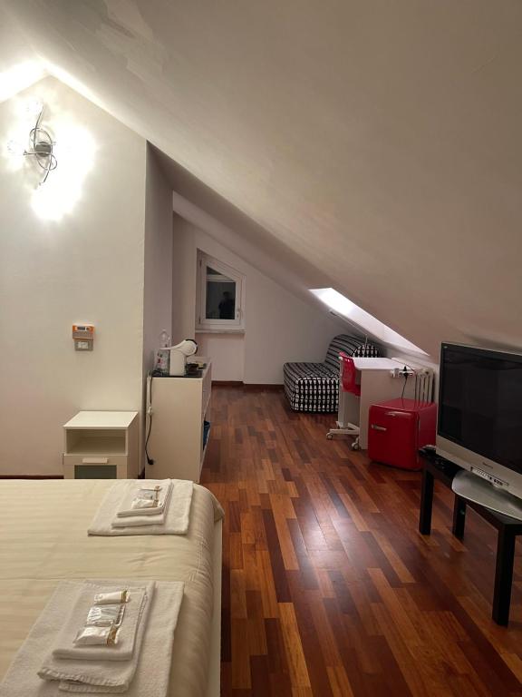 Pokój z łóżkiem, telewizorem i kanapą w obiekcie Agriturismo Ippocastano w mieście Sciolze