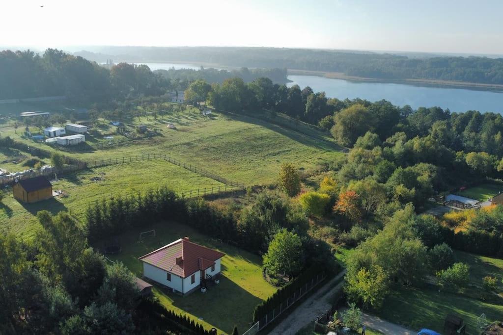 an aerial view of a house on a hill next to a lake at Włókna Inn Classic in Potrzanowo