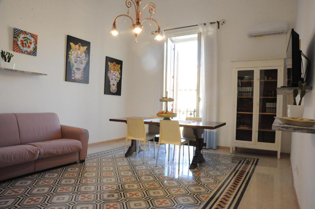 sala de estar con mesa y sofá en Massimino, en Palermo