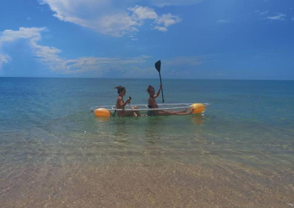 two children are sitting in a paddle boat in the water at 4U Resort Samui in Lamai