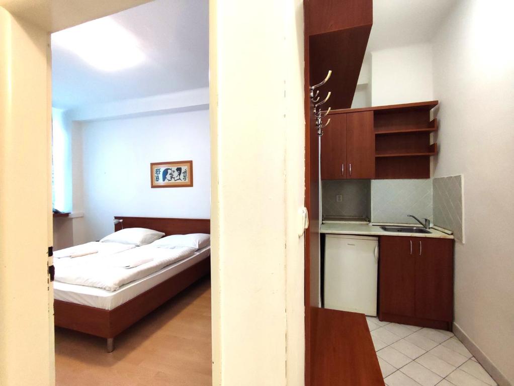 Cet appartement comprend une chambre avec un lit et une petite cuisine. dans l'établissement HOTEL JURKI Dom, à Bratislava