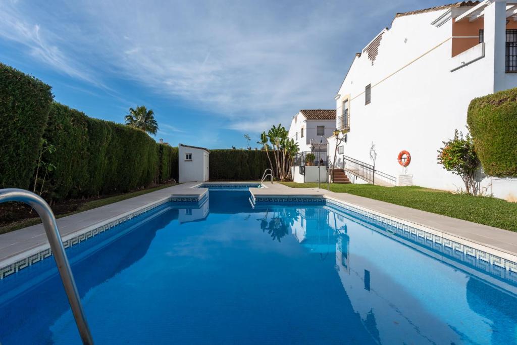 a swimming pool in front of a white house at Chalet Cortijo Blanco I in Marbella