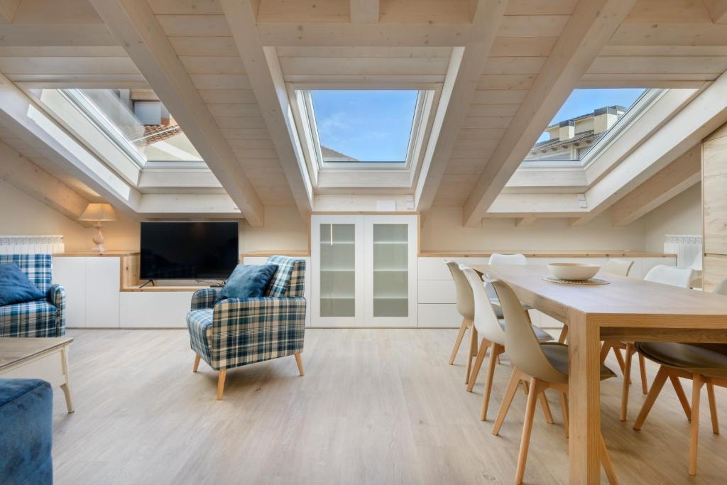 a living room with skylights and a table and chairs at Apartamentos La muralla de Jaca in Jaca