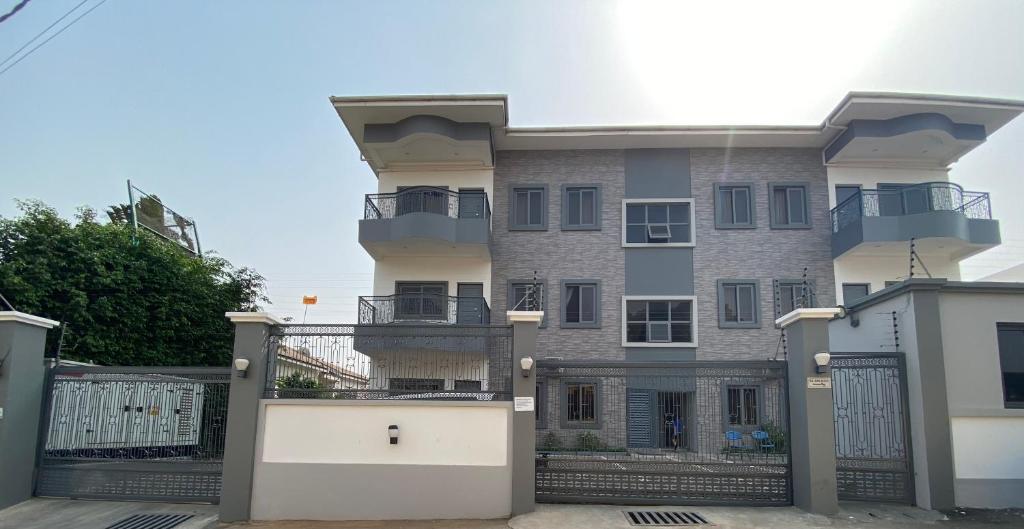 un grand bâtiment avec un portail et une clôture dans l'établissement Queens View Apartment, à Accra