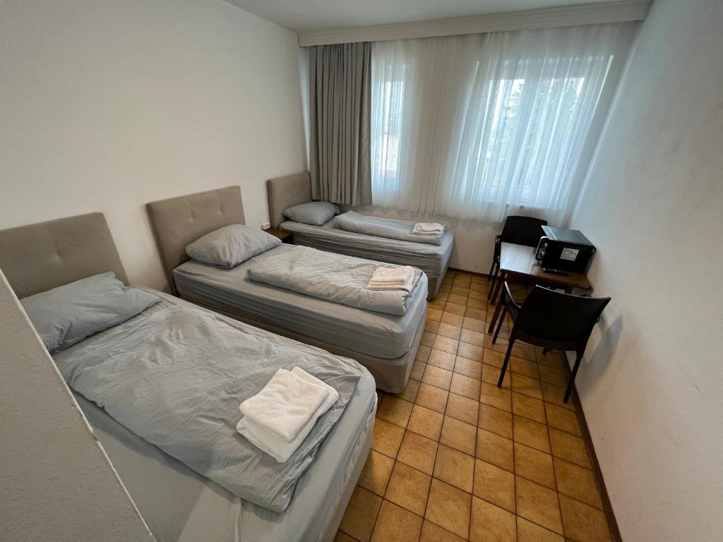 a small room with two beds and a desk at F Hotel in Hörsching