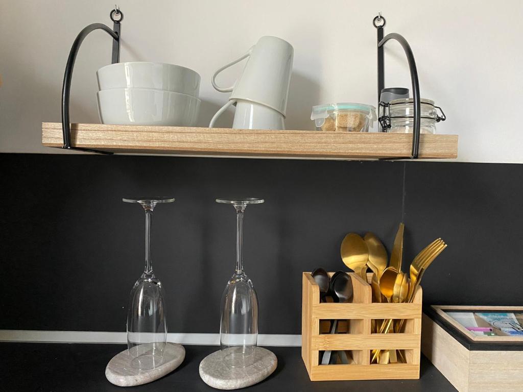 dos copas de vino en un estante con una cesta de utensilios en Gîte privé avec sauna et balnéo, en Brens