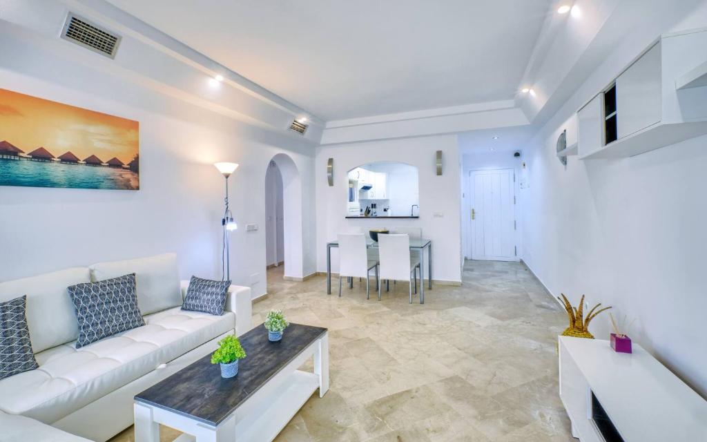 salon z białą kanapą i stołem w obiekcie Cozy Beach Side Apartment With Pool w mieście Estepona