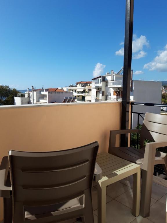 un balcone con 2 sedie e una panca sul tetto di Ξενοδοχείο Αφροδίτη- Hotel Aphrodite a Nafpaktos