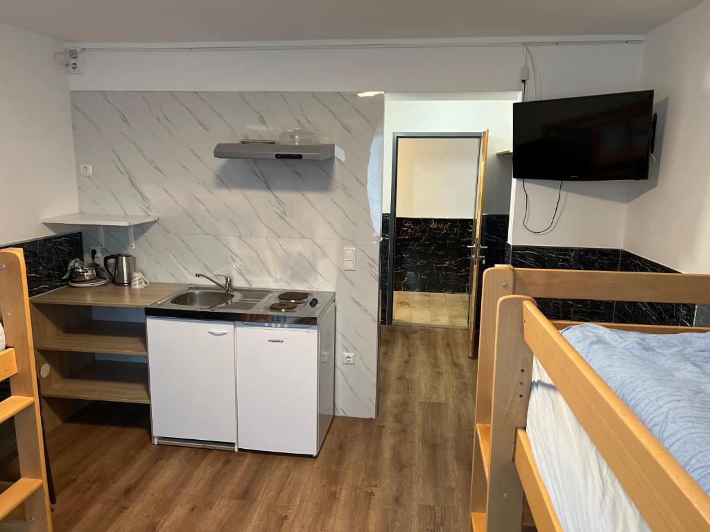 a small kitchen with a sink and a bed in a room at F Hotel in Hörsching