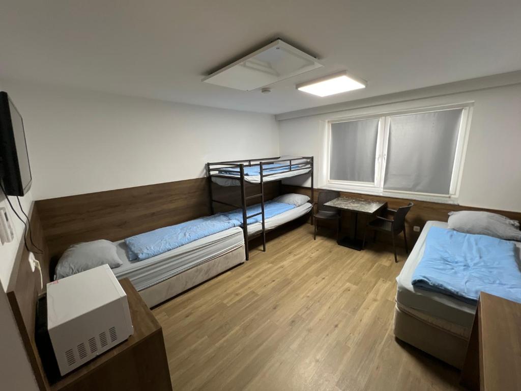 a dorm room with two bunk beds and a desk at F Hotel in Hörsching