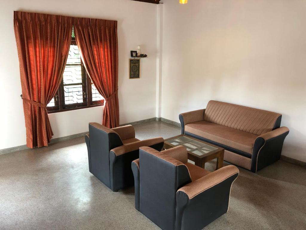 una sala de espera con sofá, sillas y ventana en SOHA Residency, en Gampaha