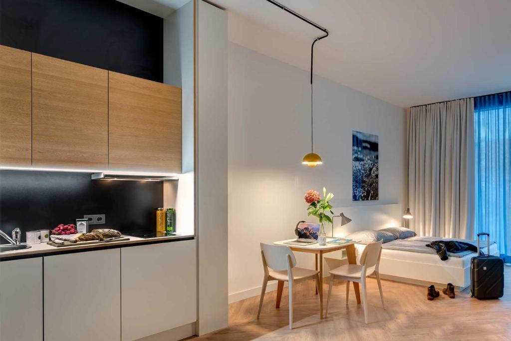 uma cozinha e um quarto com uma mesa e uma cama em SMARTments business Berlin City West em Berlim