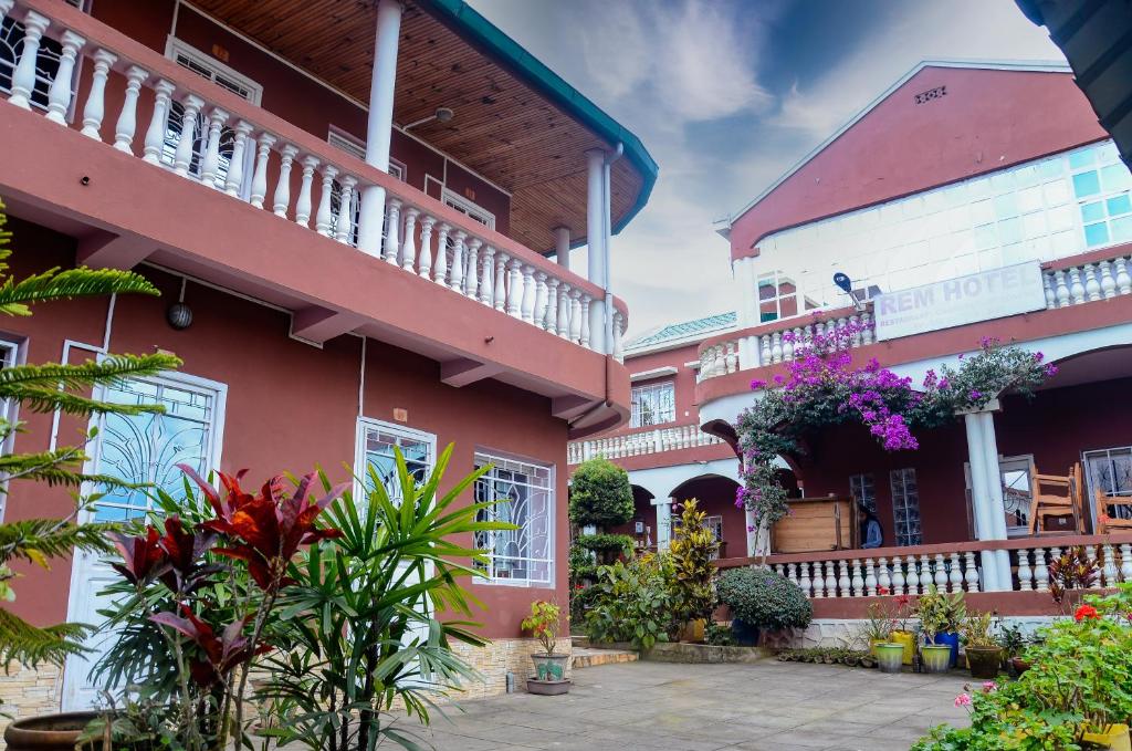菲亞納蘭楚阿的住宿－Rem Hotel，庭院里一座粉红色的建筑,里面种有植物