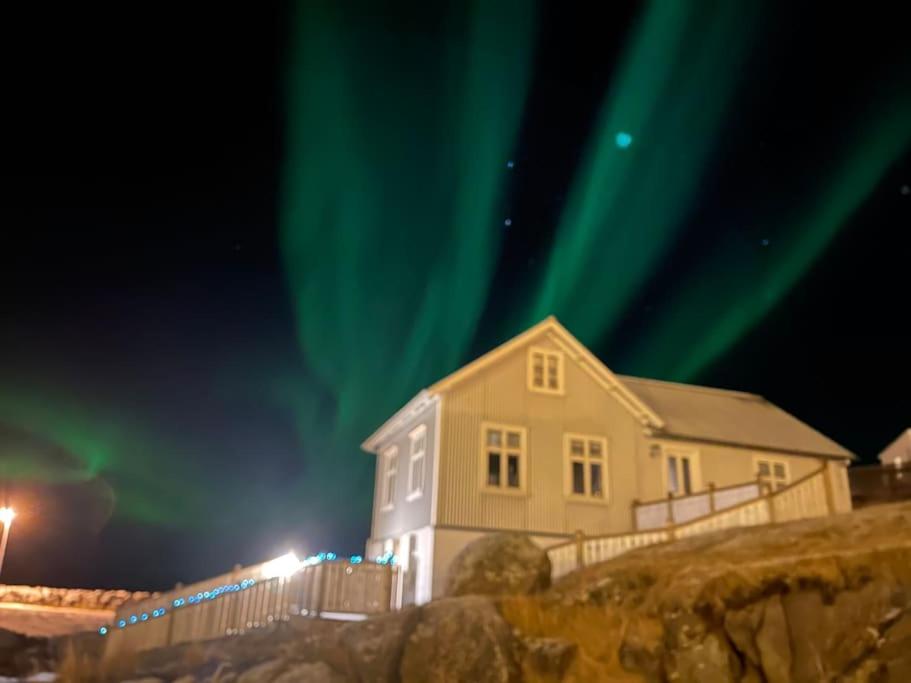 una casa con las luces del norte en el cielo en Tanginn en Stykkishólmur