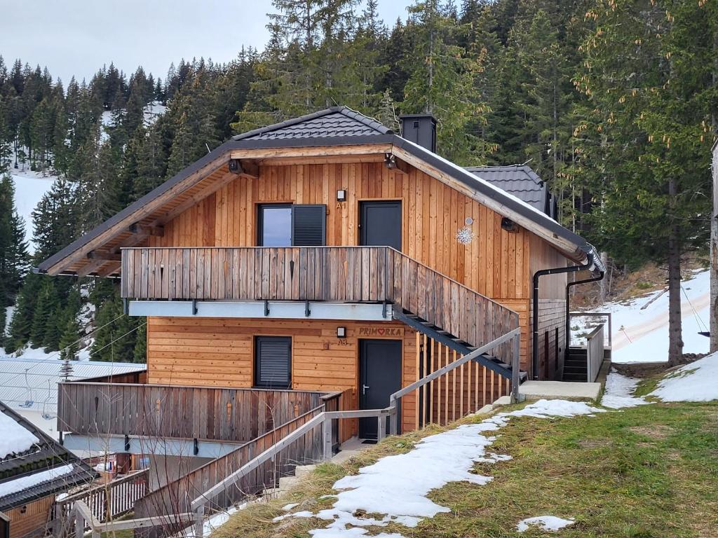 a log cabin with a staircase leading to the front door at Apartma A1 GOLTE in Mozirska Koča