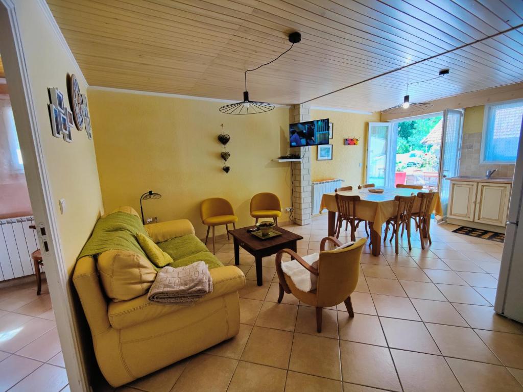 - un salon avec un canapé et une salle à manger dans l'établissement Location MarjoRI - T3 Le Kakariki, au Lauzet-Ubaye