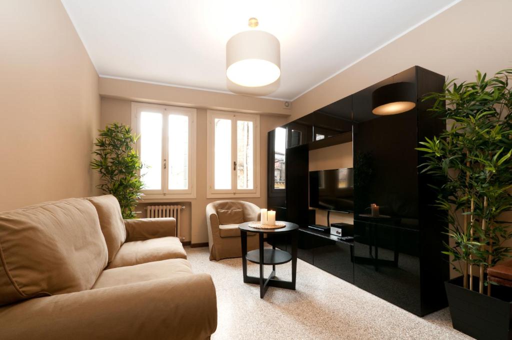 ein Wohnzimmer mit einem Sofa und einem TV in der Unterkunft Centrale Venice Apartments in Venedig
