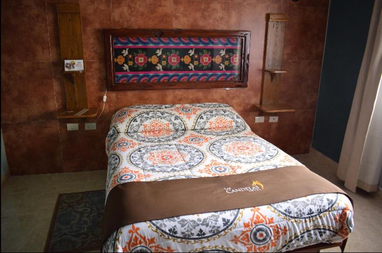 1 dormitorio con 1 cama con edredón en Hotel Las Candelas de Huamantla, en Huamantla