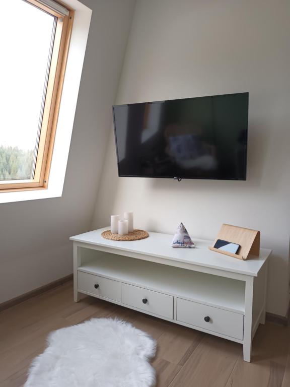 a white cabinet with a flat screen tv on a wall at Apartman LeDa - Ski centar Ravna Planina Gornje Pale in Pale