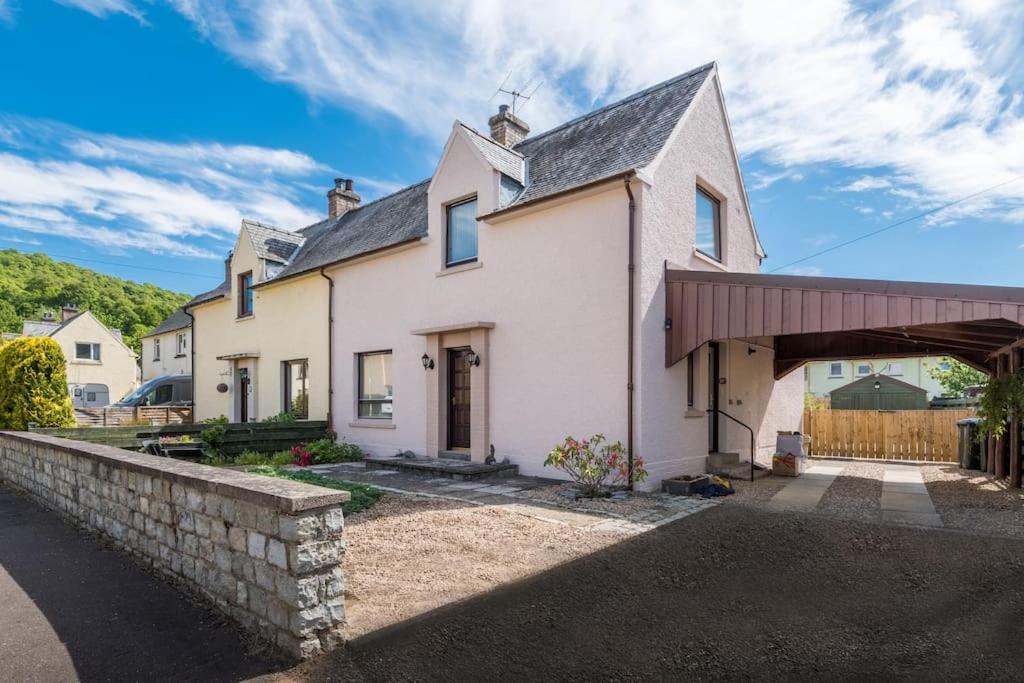 a large white house with a stone wall at No27 Willowbank in Dunkeld