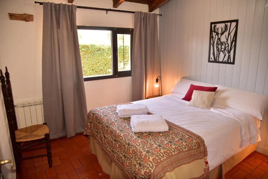 1 dormitorio con 1 cama con 2 toallas en El Mirador Bariloche en San Carlos de Bariloche