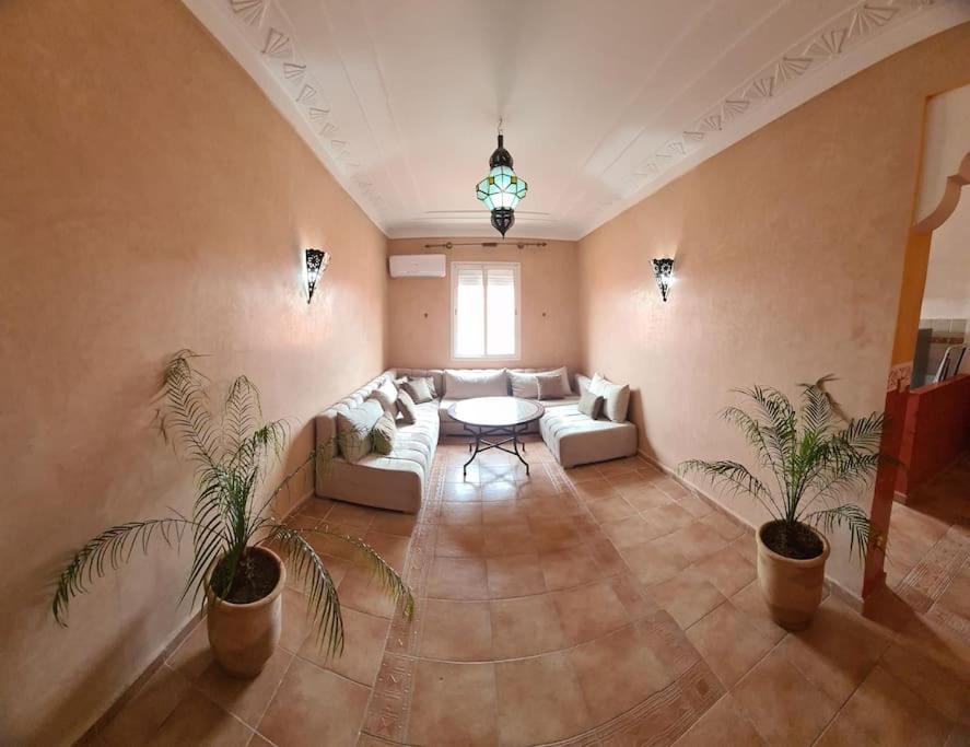 een grote woonkamer met een bank en een tafel bij Appartement te huur in Marrakech in Marrakesh