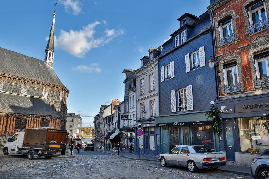 a city street with buildings and a truck and a church at La Demeure du Clocher 4 - On the Port and Place St Catherine - 8 P in Honfleur