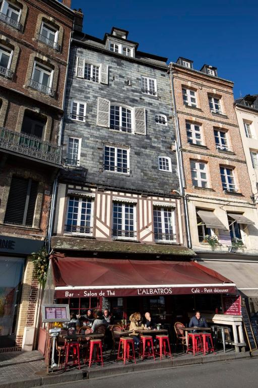 a group of people sitting at tables in front of a building at La Demeure du Clocher 4 - On the Port and Place St Catherine - 8 P in Honfleur