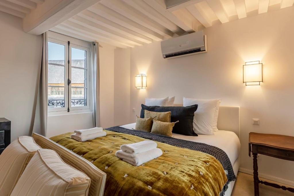 a bedroom with a large bed with towels on it at La Demeure du Clocher 4 - On the Port and Place St Catherine - 8 P in Honfleur