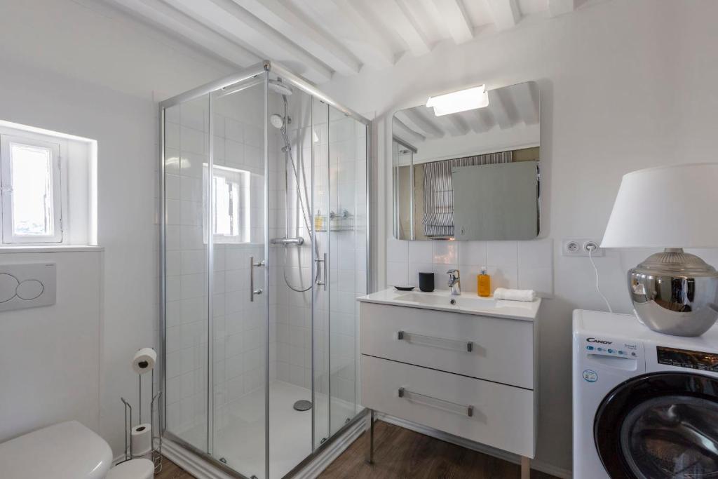 a white bathroom with a shower and a sink at La Demeure du Clocher 4 - On the Port and Place St Catherine - 8 P in Honfleur