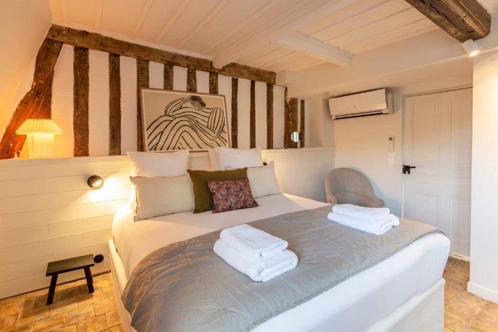 a bedroom with a bed with towels on it at La Demeure du Clocher 4 - On the Port and Place St Catherine - 8 P in Honfleur