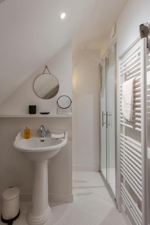 a white bathroom with a sink and a shower at La Demeure du Clocher 4 - On the Port and Place St Catherine - 8 P in Honfleur