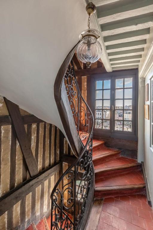 a spiral staircase in a house with a chandelier at La Demeure du Clocher 4 - On the Port and Place St Catherine - 8 P in Honfleur