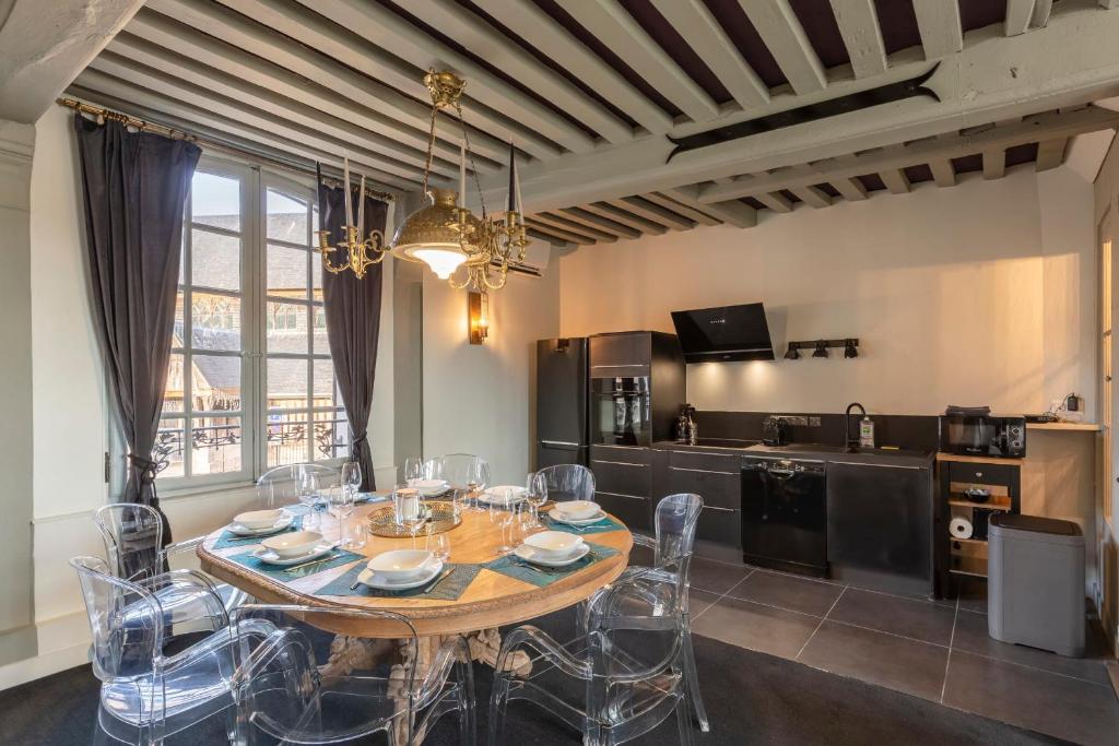 a dining room with a table and chairs and a kitchen at La Demeure du Clocher 4 - On the Port and Place St Catherine - 8 P in Honfleur